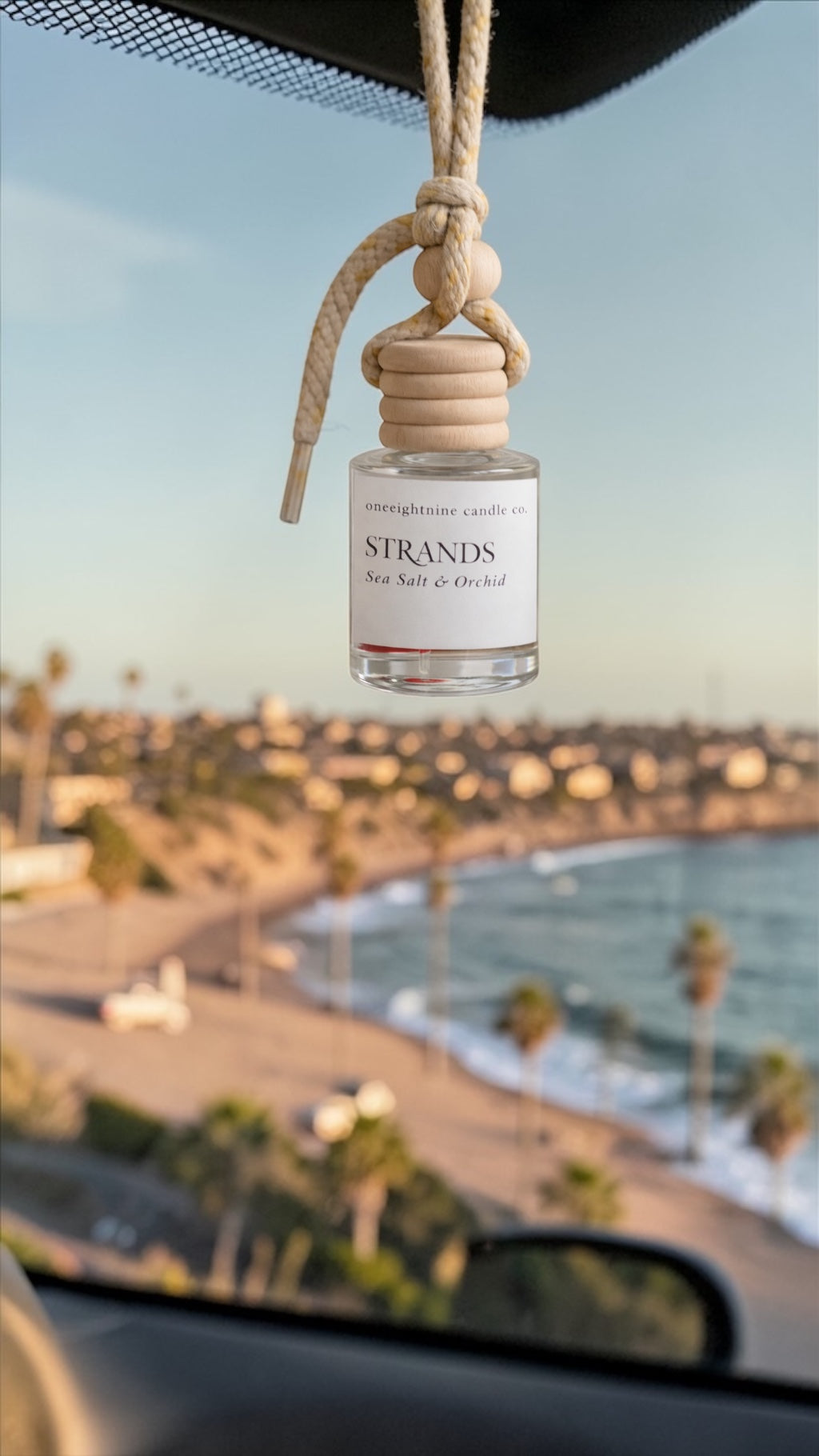 Strands hanging 8 ml car freshener diffuser with wooden top overlooking the ocean